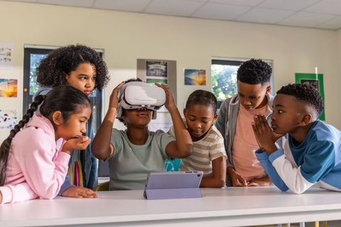 Multicultural children exploring virtual reality together during interactive classroom learning