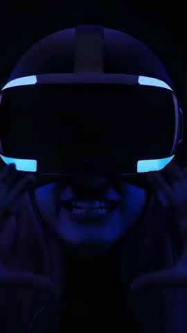 Woman adjusting VR headset with neon blue LED glow closeup vertical tech video