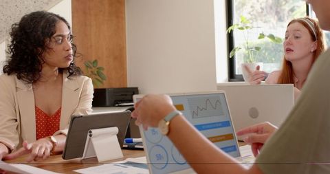 Diverse Coworkers Collaborate on Business Strategy with Laptop Charts