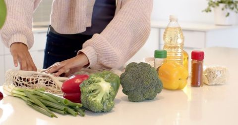 Indian Woman Unpacking Groceries on Modern Kitchen Island