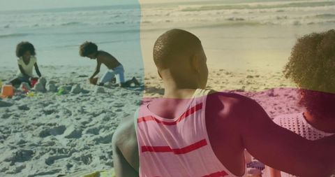 Family relaxing on sunny beach, children building sandcastles and playing by ocean