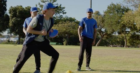 Coach running drill holding disc and whistle during ultimate frisbee training on grass