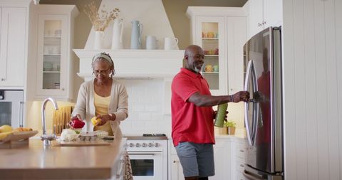 Senior African American Couple Enjoying Domestic Chores in Kitchen