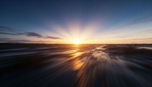 Low sun golden rays reflecting on tidal flats with dramatic motion blur at sunset
