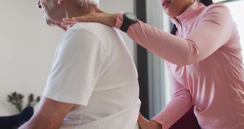 Physiotherapist Assisting Senior Man with Exercises