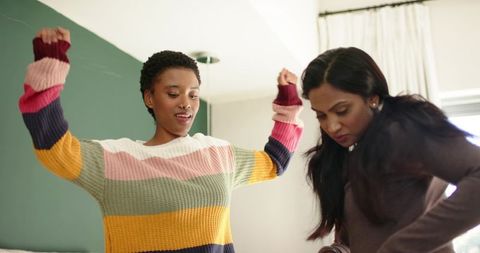 Diverse Female Friends Dancing Beside Stylish Headboard