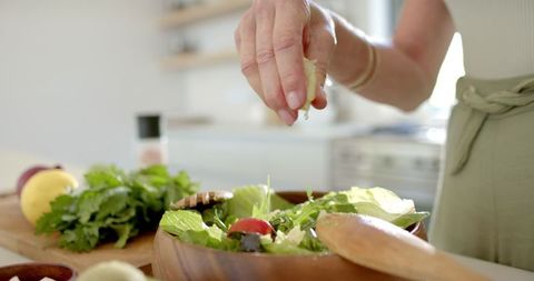 Hand Seasoning Fresh Salad in Bright Contemporary Kitchen - Download Free Stock Images Pikwizard.com