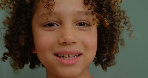 Smiling biracial child with curly hair in slow motion