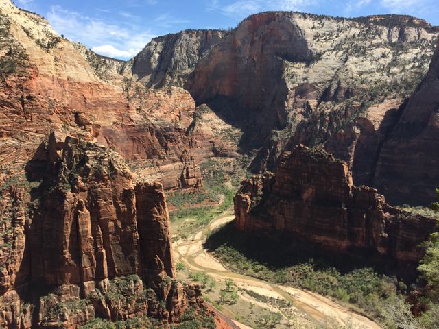 Stunning view of Zion National Park canyon showcasing towering sandstone cliffs and rugged mountains under clear blue sky. Ideal for use in travel blogs, adventure advertisements, and nature conservation material.