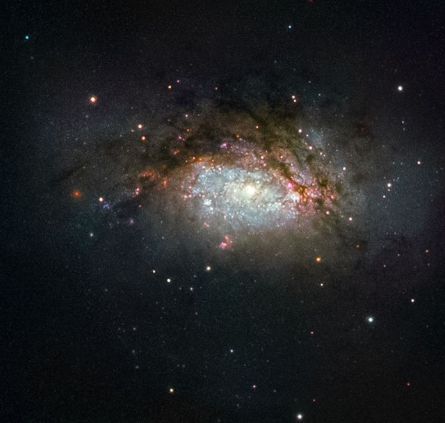 NGC 3597, the focus of this image from NASA/ESA Hubble Space Telescope, is the product of a collision between two sizable galaxies. It is located approximately 150 million light-years away in the Crater constellation. This photo highlights the transformative process as NGC 3597 evolves into a giant elliptical galaxy, an event marked by intense star birth from pooled gas and dust. Studying instances like these lends insight into the formation of elliptical galaxies, often termed ‘red and dead’ by astronomers when they cease creating new stars. This stellar snapshot can be utilized in educational materials on galaxy formation, space exploration campaigns, or astrophotography showcases.