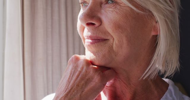 Serene Elderly Woman Contemplating Life Near Sunlit Window - Download Free Stock Images Pikwizard.com