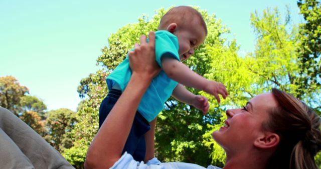 Mother lifting baby outdoors in sunny park, bonding and fun time - Download Free Stock Images Pikwizard.com