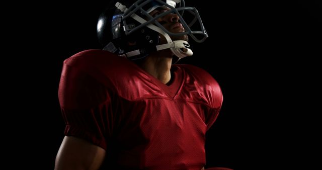 American Football Player in Helmet Looking Upwards in Dark Background - Download Free Stock Images Pikwizard.com
