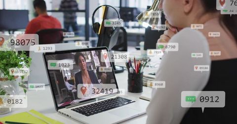 Watching remote meeting with floating data overlays in modern open office workspace