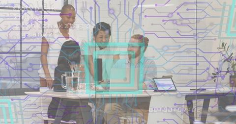 Diverse team collaborating around monitor with digital circuit overlay in modern office