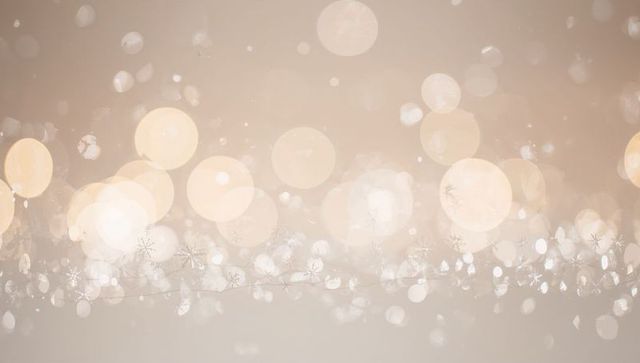 Glowing warm beige bokeh with snowflake garland creating festive ethereal backdrop