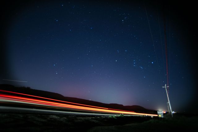 Starry Night Sky with Car Light Trails at Countryside - Download Free Stock Photos Pikwizard.com