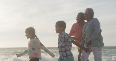 Joyful Family Enjoying Beach Walk during Sunset