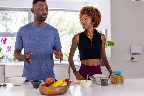 African american couple preparing healthy breakfast at modern kitchen island during morning