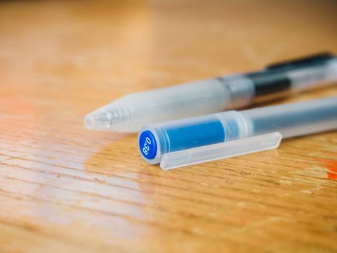 Close-up of ballpoint pens on wooden desk surface