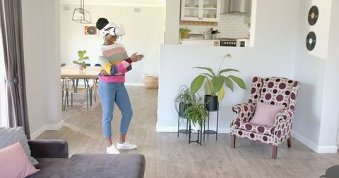 Woman engaging with virtual reality headset in modern living room