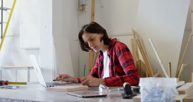 Young Woman Working on Laptop in Workshop - Download Free Stock Images Pikwizard.com