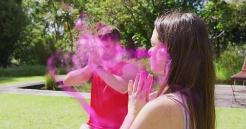 Couple meditating outdoors with vibrant pink color in nature