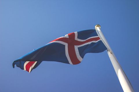 Iceland flag flying on flagpole against clear blue sky symbol of national pride
