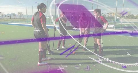 Field hockey team gathering while coach placing ball on pitch with purple graphic overlay