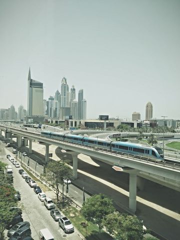 Modern metro train traversing urban cityscape with skyscrapers