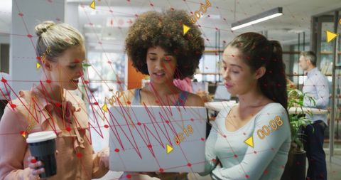 Diverse Female Colleagues Analyzing Data on Laptop in Modern Office