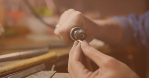 Artisan Jeweler Polishing Ring in Workshop