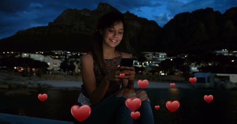 Young Woman with Smartphone and Romantic Hearts at Night by Beach