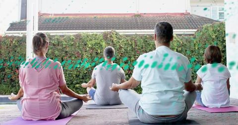 Four adults meditating together on backyard patio during outdoor mindfulness session