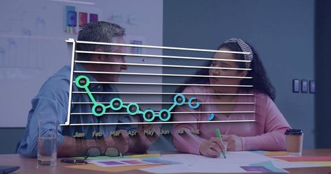 Team Collaborating on Project with Line Chart Overlay Analysis