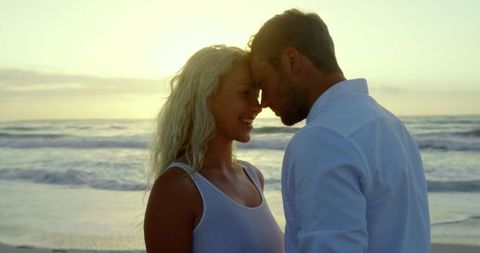 Romantic Couple on Beach at Sunset Embracing Happy Moment