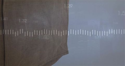 Draping woven brown fabric on grey wall with subtle waveform overlay and numeric marks