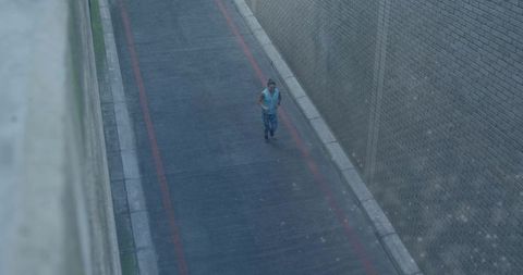 Woman walking through narrow urban alley between brick walls on damp pavement