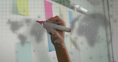Collaborative planning on glass board with dotted world map, sticky notes and pink marker