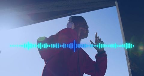 Man enjoying music on headphones under sunny sky