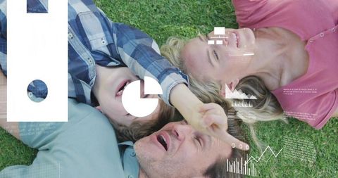 Family lying on grass smiling and pointing with digital data overlays for lifestyle tech