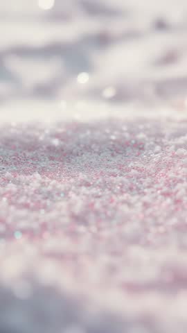 Panning across pastel pink crystal flecks revealing sparkling macro texture — vertical video