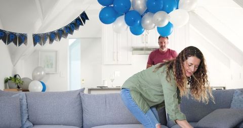 Couple tidying up after birthday celebration at home