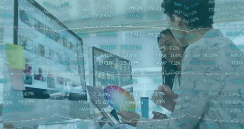 Coworkers Analyzing Financial Charts with Technology in Modern Office