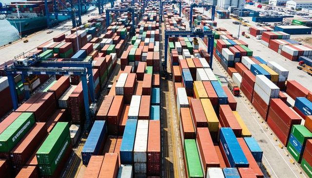 Aerial view showing container terminal stacking colorful shipping containers under gantry cranes