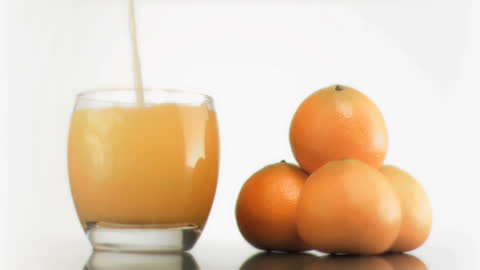Refreshing Citrus Smoothie Pouring Next to Fresh Oranges