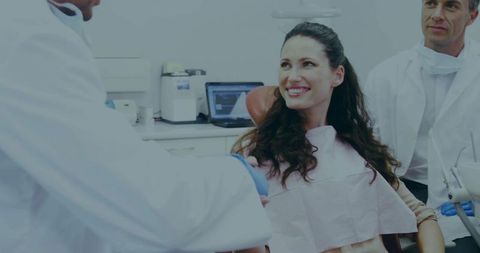 Smiling dental patient receiving warm dentist consultation in modern dental clinic