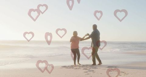 Mature Couple Dancing on Beach with Heart Overlay