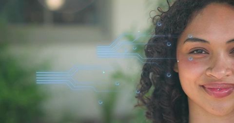 Smiling woman gazing in garden with blue circuit hologram overlay, tech portrait