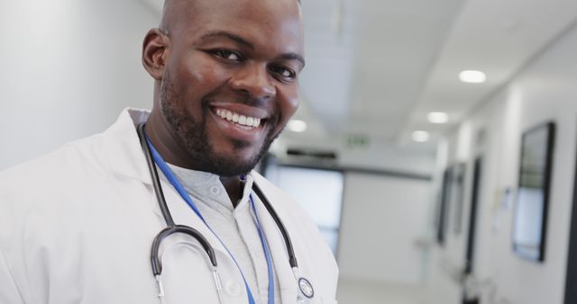 Confident African American Doctor Smiling in Hospital Corridor with Stethoscope - Download Free Stock Images Pikwizard.com